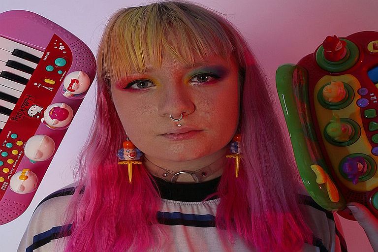 Person looking into the camera with games consoles