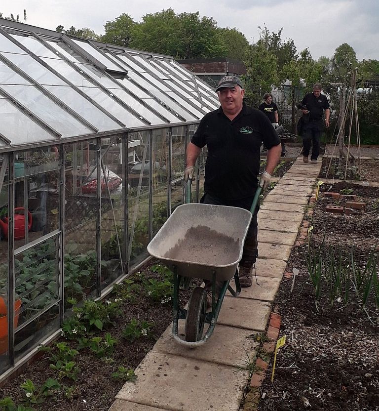 Person working with a wheelbarrow at the allotment