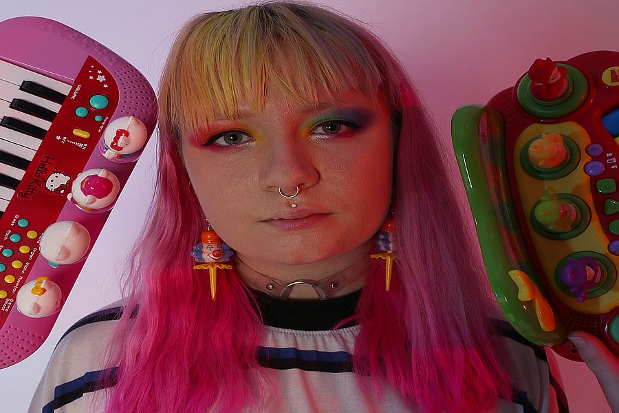 person smiling for the camera with games consoles