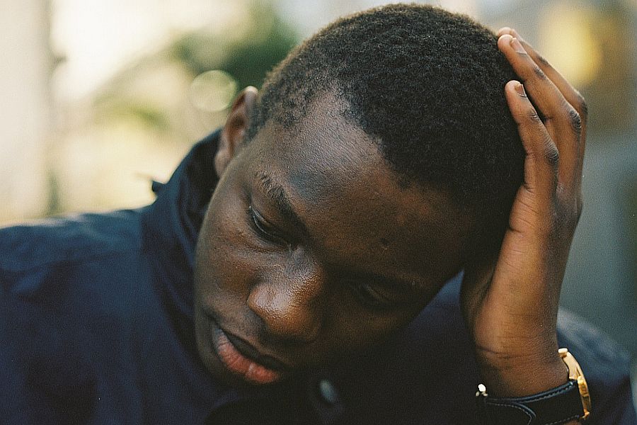 Photo of a person thinking with head in hand