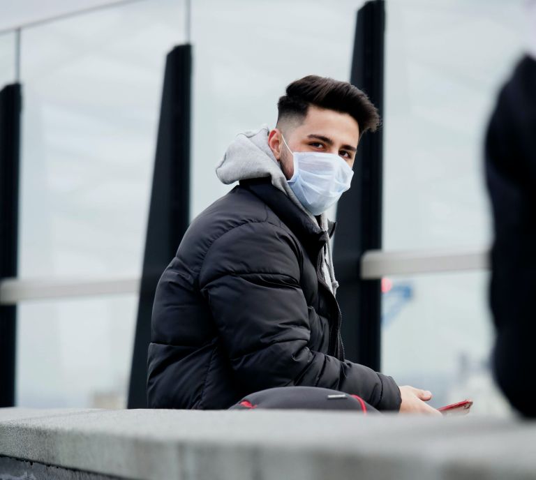 person in facemask looking into camera