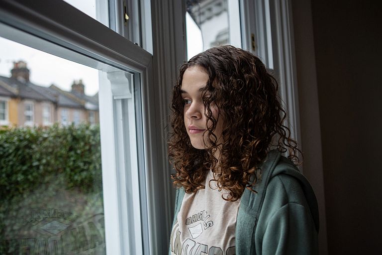 Young person looking out of a window