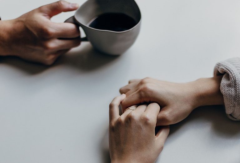 close up of hands of people having a drink